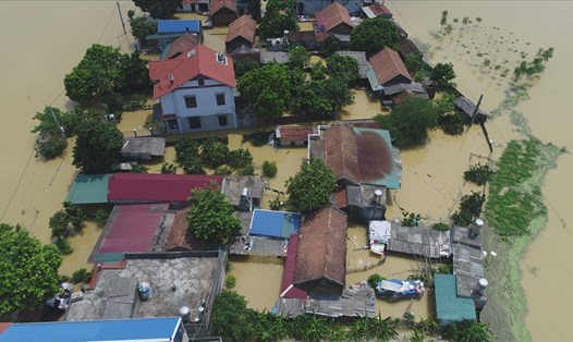 Người dân thôn Bùi Xá (Xuân Mai, Quốc Oai, Hà Nội) vẫn đang phải sống trong biển nước lũ sau bão. Ảnh. Văn Thắng