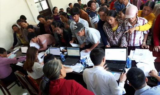 Cán bộ BHXH hướng dẫn người dân thực hiện công tác đồng bộ mã số BHXH tại xã Vinh Hà, huyện Phú Vang, tỉnh Thừa Thiên - Huế. Ảnh: P.D