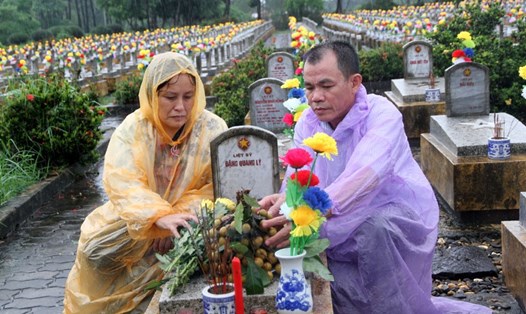 Vợ chồng bà Hoàn thấy được an ủi khi phần mộ của liệt sĩ Đặng Quang Lý được chăm sóc chu đáo. Ảnh: HƯNG THƠ