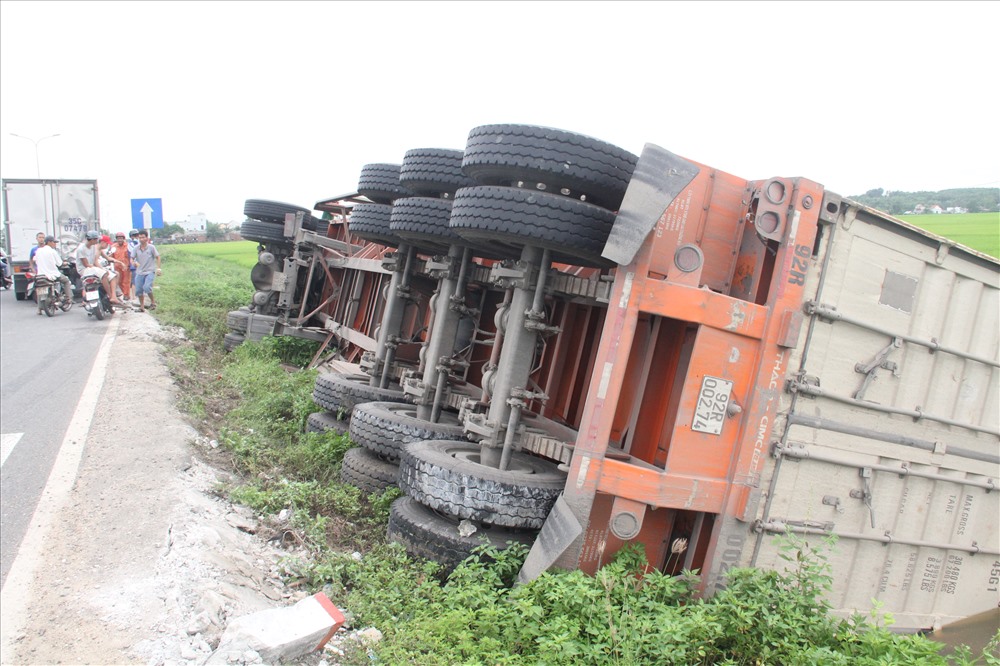 Chiếc xe container bị lật phơi bụng dưới mương nước. Ảnh: Đ.V