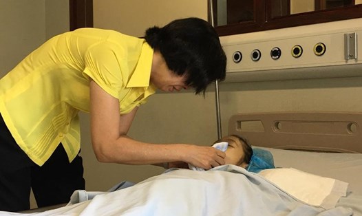 Chị Nguyễn Thị Hải Vân hôn tạm biệt con gái sau khi con đã hiến giác mạc. 