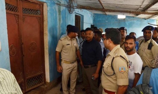 Cảnh sát và cư dân bên ngoài lối vào tòa nhà nơi các thành viên của gia đình 7 người được tìm thấy trong tư thế treo cổ ở Ranchi, Ấn Độ, vào ngày 30.7. Ảnh: AFP. 