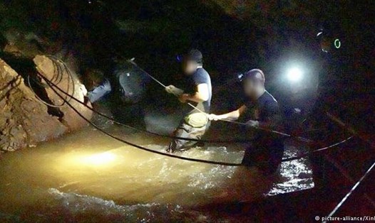 Các thợ lặn đặc nhiệm SEAL đánh giá mực nước tại một khoang ngầm trong hang.