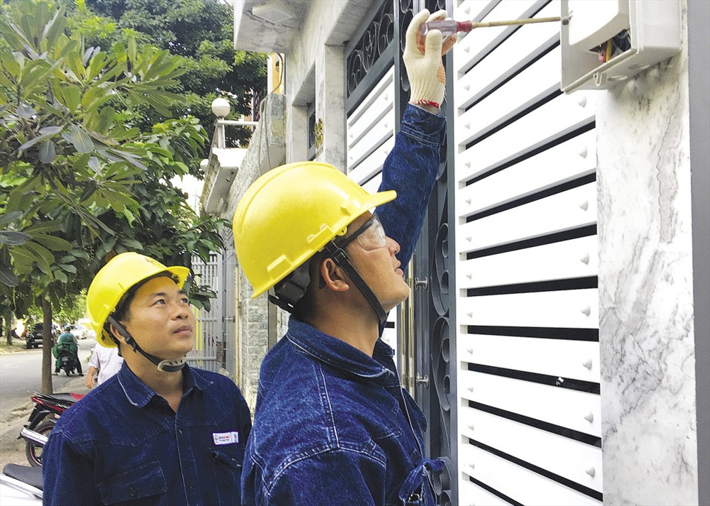 Anh Nguyễn Văn Trọn (bên trái) cùng đồng nghiệp kiểm tra hộp bảo vệ điện kế có gắn kính cường lực.