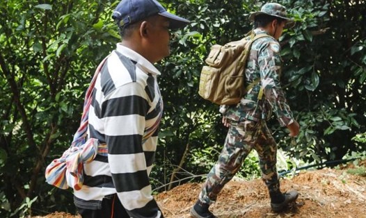 Thợ tìm tổ yến đảo Libong (trái) và lực lượng kiểm lâm ở khu vực hang Tham Luang. Ảnh: AFP. 