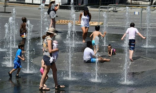 Người dân ở Montreal tập trung tại một đài phun nước vì nóng bức. Ảnh: AFP. 