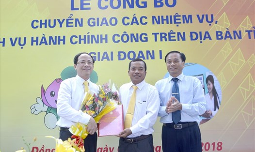 Ông Nguyễn Văn Dương (phải) cùng ông Phạm Anh Tuấn tặng hoa cho đại diện Bưu điện Đồng Tháp trong lễ công bố. Ảnh: Lâm Lý 