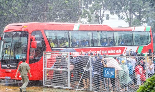 Rất đông người hâm mộ đã đội mưa để bao vây xe chở ĐT U23 Việt Nam ngay trước sân Gò Đậu. Ảnh: Huy Po