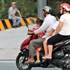 Hiện nay, nhiều bậc phụ huynh vẫn rất chủ quan khi không đội mũ bảo hiểm cho con khi tham gia giao thông bằng mô tô, xe gắn máy. Ảnh tư liệu/ Trường Sơn