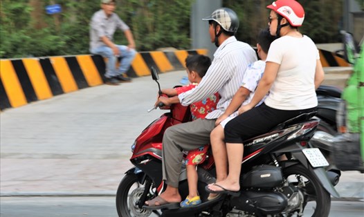 Hiện nay, nhiều bậc phụ huynh vẫn rất chủ quan khi không đội mũ bảo hiểm cho con khi tham gia giao thông bằng mô tô, xe gắn máy. Ảnh tư liệu/ Trường Sơn
