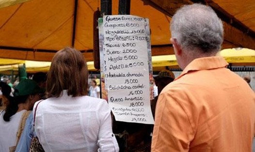Người dân xem bảng giá tại một khu chợ ở thủ đô Caracas, Venezuela hôm 18/8. Ảnh: Reuters.