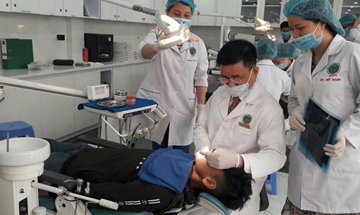 BS khám răng cho một bệnh nhân người Malaysia. Ảnh: THÙY LINH