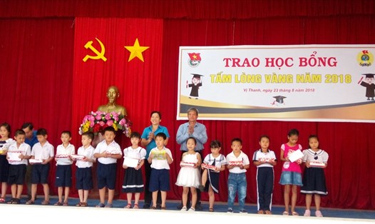 Chủ tịch LĐLĐ tỉnh Hậu Giang - Lê Thị Thanh Lam và lãnh đạo Thành ủy Vị Thanh trao quà cho các em học sinh.