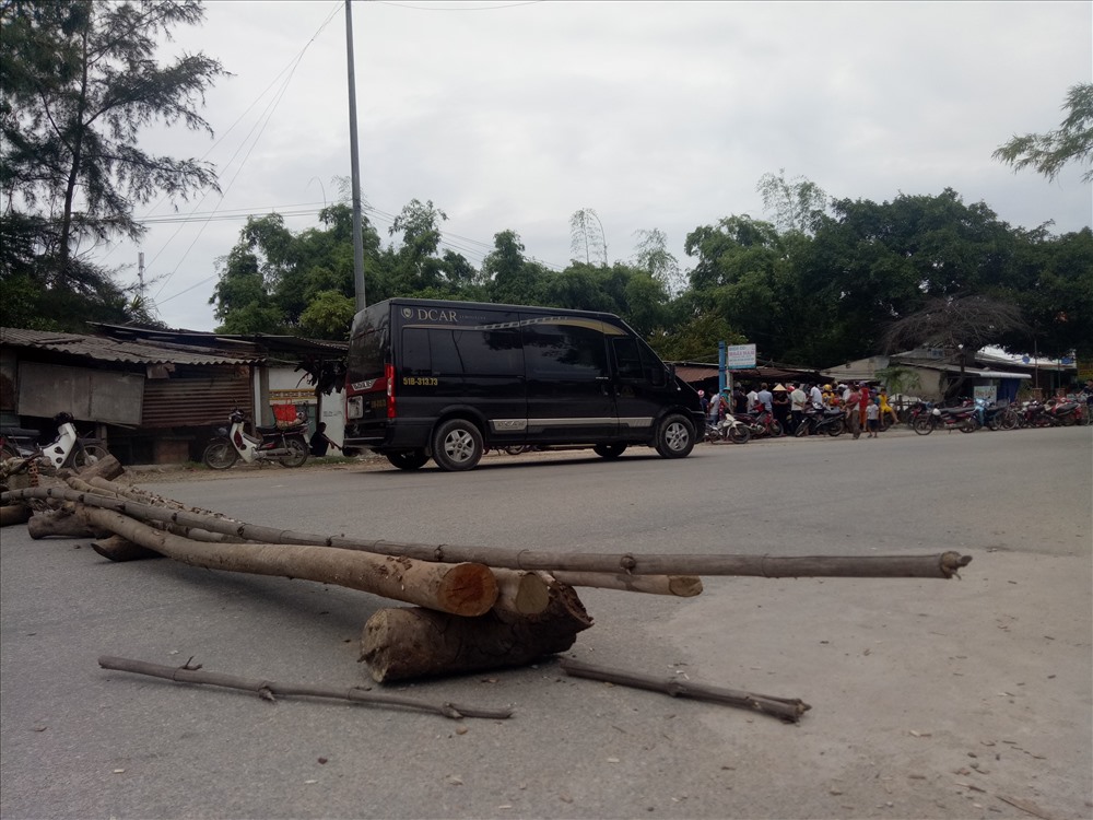 Người dân dùng cây làm vật cản ngăn chặn xe chở gỗ dăm trên QL24C. Ảnh:TH