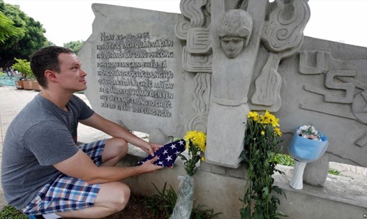 Giáo viên tiếng Anh người Mỹ Derek Davis tới đặt hoa tưởng nhớ Thượng nghị sĩ John McCain bên hồ Trúc Bạch hôm 26.8. Ảnh: Reuters