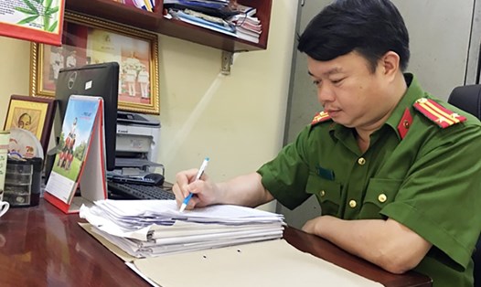 Trung tá Vương Hồng Sâm nghiên cứu hồ sơ vụ án. Ảnh: BCA.