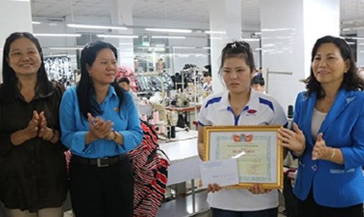 Bà Lê Thanh Tiền (ngoài cùng bên phải) trao khen thưởng cho công nhân Nguyễn Thị Tú Hảo. Ảnh: K.Q
