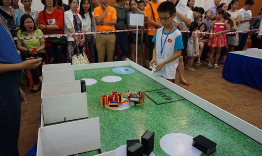 Các em học sinh điều khiển robot tham gia phần thi "tái chế vật liệu".  Ảnh: M.Q