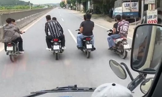 8 thanh niên đầu trần trên 4 xe máy chạy dàn ngang quốc lộ (ảnh cắt từ clip).
