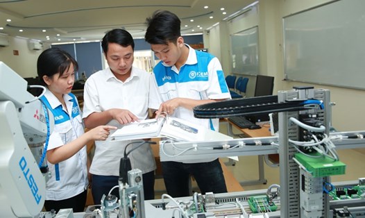 Nguyễn Văn Hưng và Nguyễn Thị Bích Thùy (học viên trường Cao đẳng Cơ điện Hà Nội) cùng thầy giáo Nguyễn Xuân Nguyên (giữa) tại phòng điều khiển công nghiệp 4.0. Ảnh: HẢI NGUYỄN