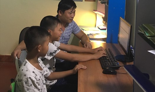 Nhờ chiếc máy tính là quà tặng của Thủ tướng Nguyễn Xuân Phúc, anh Vũ Xuân Đạt cùng các con thường xuyên vào Internet để nâng cao kiến thức. Ảnh: VŨ HẢI