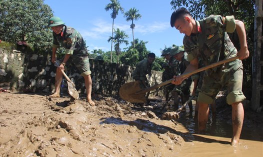 Bộ đội giúp dân xã Cẩm Phong, huyện Cẩm Thuỷ dọn bùn sau lũ. Ảnh: Xuân Hùng 