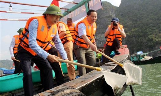 Bí thư tỉnh ủy Quảng Ninh Nguyễn Văn Đọc (trái) tham gia thả cá giống nhằm tái tạo, bổ sung nguồn thủy sản cho vịnh Hạ Long. Ảnh: Nguyễn Hùng