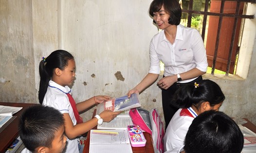 Đại diện EVN HANOI trao tặng những cuốn vở tới các em học sinh. Ảnh: Huyền Trang
