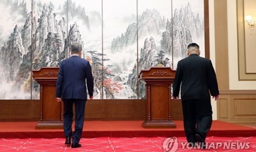 Tổng thống Hàn Quốc Moon Jae-in (trái) và lãnh đạo Triều Tiên Kim Jong-un bước lên vị trí chủ trì họp báo công bố kết quả hội nghị thượng đỉnh liên Triều tại nhà khách nhà nước Paekhwawon, Bình Nhưỡng ngày 19.9. Ảnh: Yonhap. 