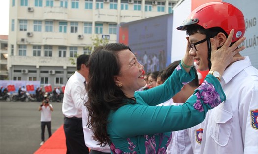 Thứ trưởng Nguyễn Thị Nghĩa trao mũ bảo hiểm cho học sinh, sinh viên. Ảnh: VC