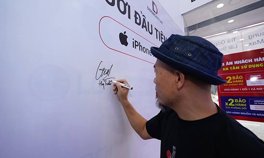 Nhạc sĩ Huy Tuấn kí lên bảng là người đầu tiên sở hữu iPhone 2018 tại Di Động Việt.