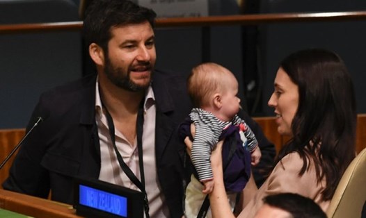 Nữ Thủ tướng New Zealand bế con gái trong phòng họp, bên cạnh là bạn trai bà. Ảnh: AFP. 