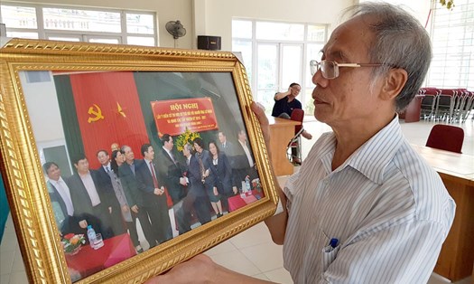 Ông Đĩnh cầm trên tay bức ảnh trong một lần ông được chụp với Chủ tịch nước Trần Đại Quang. Ảnh CN.