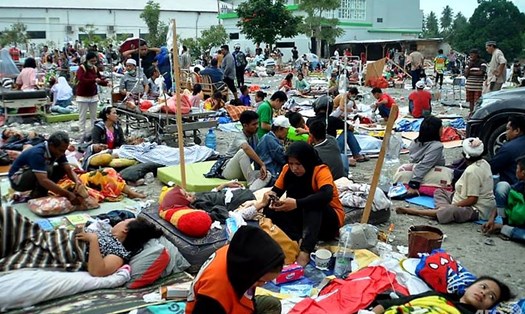 Bệnh viện không còn đủ chỗ, người bị thương phải nằm vạ vật bên ngoài sau động đất, sóng thần ở Palu. Ảnh: AFP.