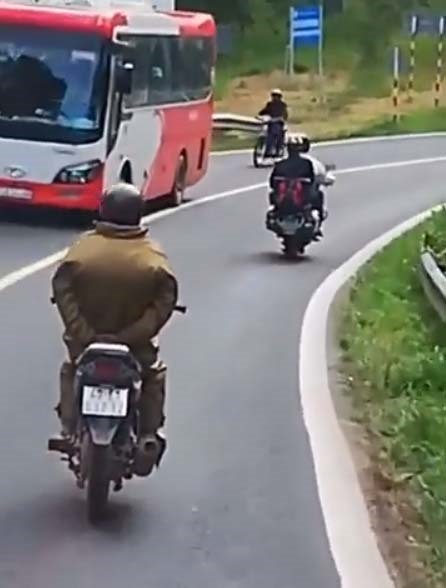 Người đàn ông chắp tay phía sau điều khiển xe máy trên đèo Prenn ( Ảnh: Cắt từ Clip).