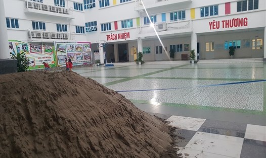 Đống cát, gạch vẫn còn nguyên trong khuôn viên nhà trường trong ngày khai giảng. Ảnh: HN
