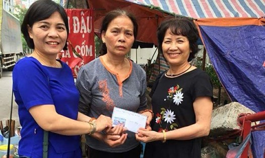 Bà Nguyễn Thị Minh (bên phải) giúp đỡ gia đình có hoàn cảnh khó khăn.