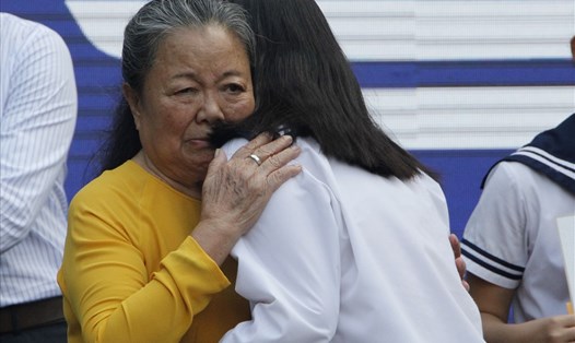Vợ nhà giáo Văn Như Cương thay mặt thầy trao những cái ôm yêu thương đến các em học sinh. Ảnh: Nguyễn Hà