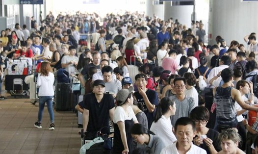 Hành khách mắc kẹt tại sân bay quốc tế Kansai xếp hàng đi xe buýt đi đến trung tâm Osaka hôm 5.9. Ảnh: Kyodo. 