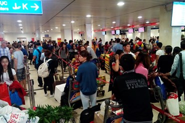 Khách xếp hàng dài làm thủ tục ở sân bay Tân Sơn Nhất dịp cao điểm Tết.  Ảnh: M.Q