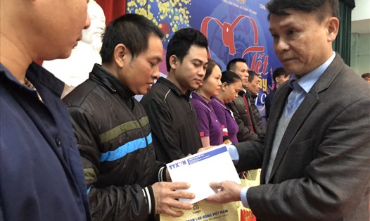 Đồng chí Nguyễn Đức Lợi (phải) - Uỷ viên Trung ương Đảng, TGĐ TTXVN - tặng quà và động viên NLĐ Cty In thương mại TTXVN.