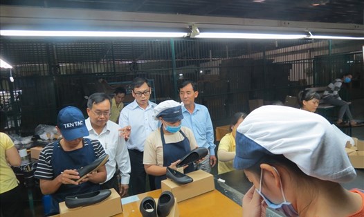 Ông Huỳnh Văn Tuấn (phải ảnh) trao đổi với chủ DN tại nhà xưởng và lắng nghe ý kiến CN - Ảnh: L.T