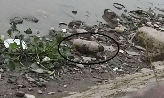 Quả bom dài gần 1 mét được người dân phát hiện ở ven sông. Ảnh: CTV.