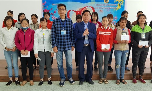 Đại diện lãnh đạo LĐLĐ tỉnh Ninh Bình và lãnh đạo công ty tặng quà cho CNLĐ có hoàn cảnh khó khăn. Ảnh: NT
