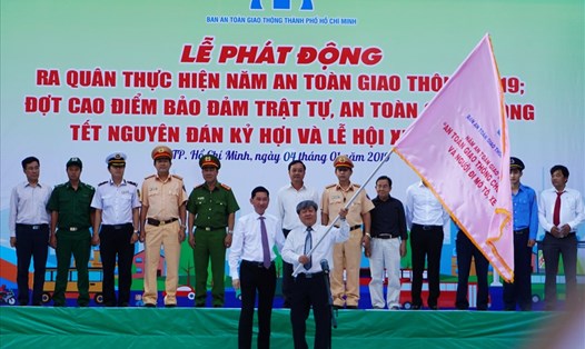 Phó Chủ tịch UBND TPHCM Trần Vĩnh Tuyến trao cờ phát động ra quân thực hiện năm An toàn giao thông 2019. Ảnh: M.Q