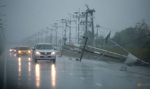 Ôtô và cột điện rơi xuống được nhìn thấy dọc theo một con đường khi cơn bão nhiệt đới tiếp cận tỉnh Nakhon Si Thammarat, Thái Lan, ngày 4.1. Ảnh: Reuters 