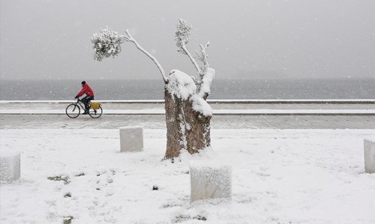 Một người đàn ông đi trong mưa tuyết ở Hy Lạp.