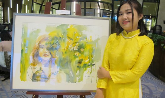 Nữ họa sĩ Lê Ngọc Quỳnh bên tác phẩm tại triển lãm cá nhân đầu tiên của mình. Ảnh: L.Q.V