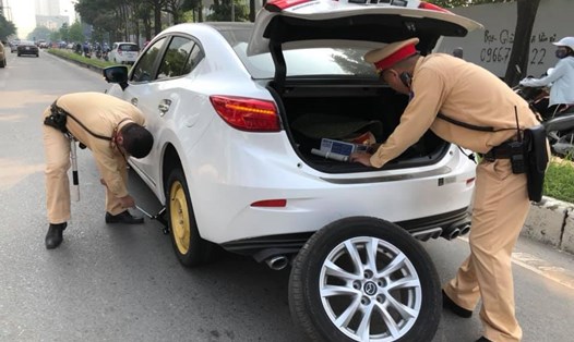 Hai chiến sĩ Cảnh sát giao thông - Công an Hà Nội giúp người tham gia giao thông thay lốp xe. Ảnh: Nguyễn Hương