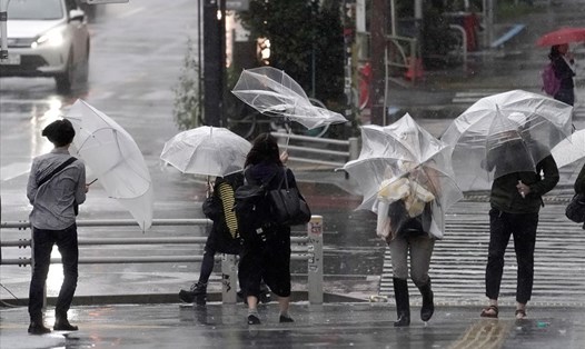 Người dân vật lộn với gió lớn ở Tokyo. Ảnh: EPA